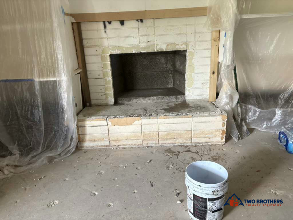 Exposed fireplace with plastic room protection and a work bucket